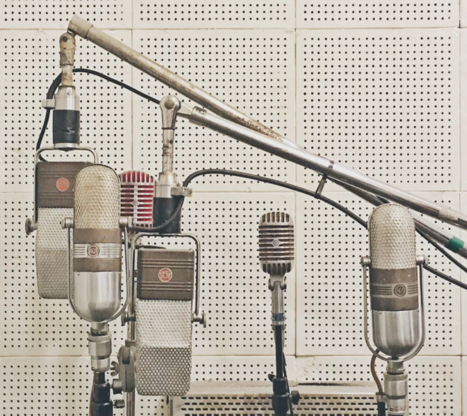 Vintage studio microphones on stands in a recording room
